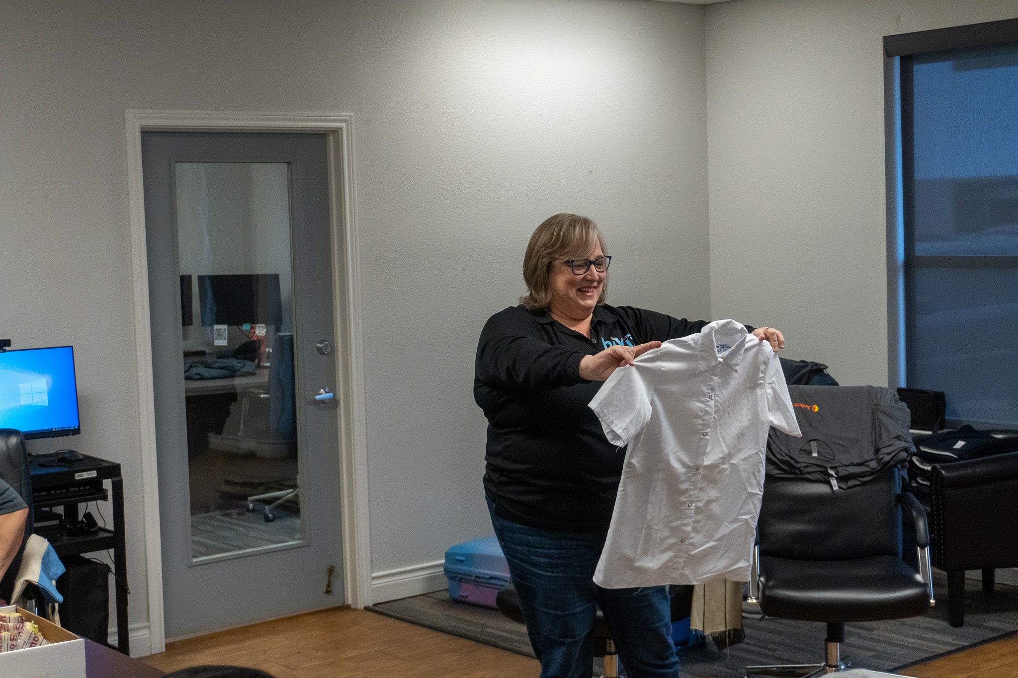 Person holding a white shirt in an office setting